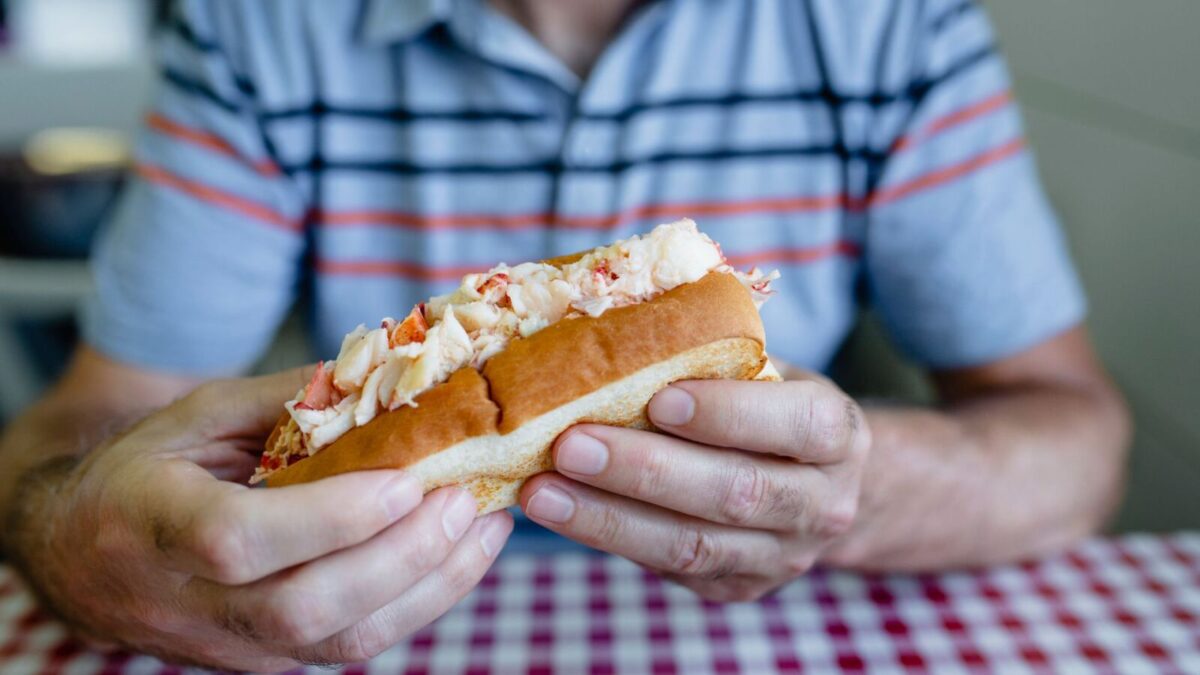 A patron enjoying their lobster roll in Narragansett