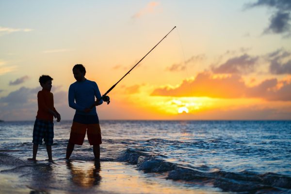 two young boys fishing in the ocean